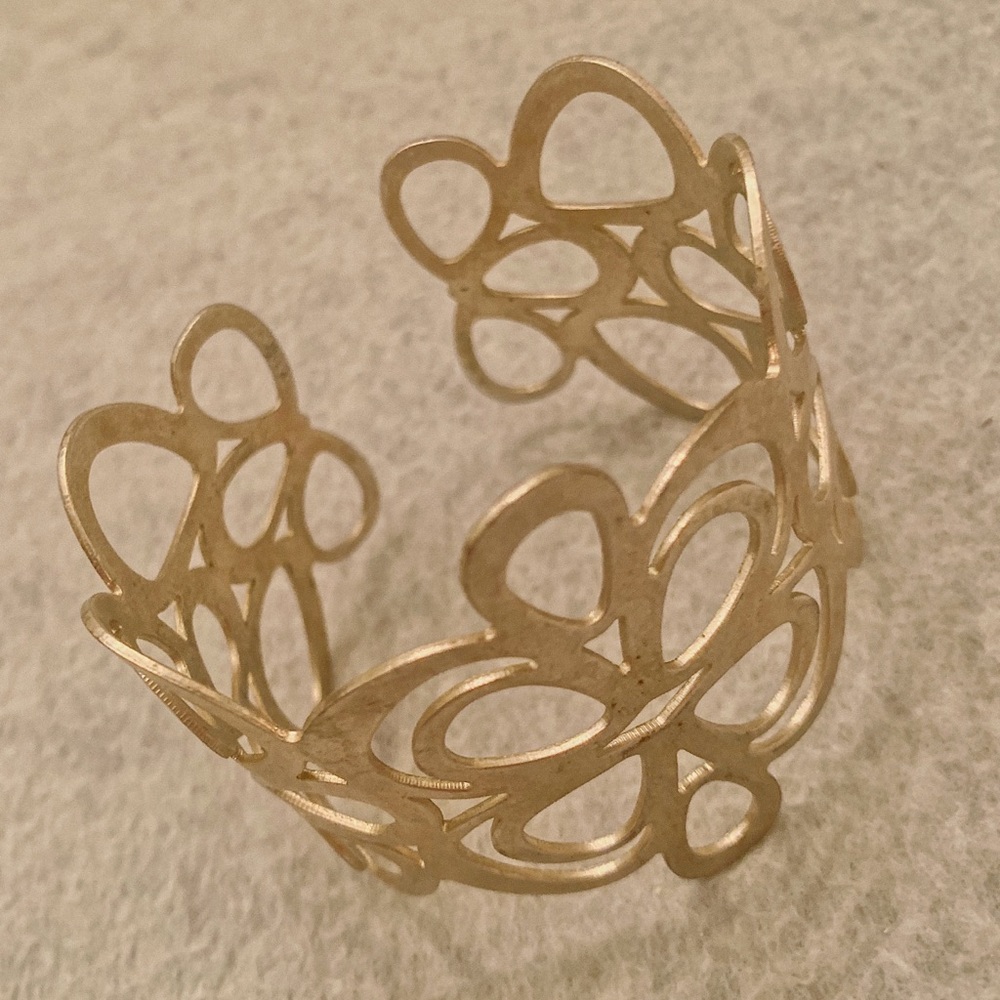 Gold tone metal cuff bracelet.